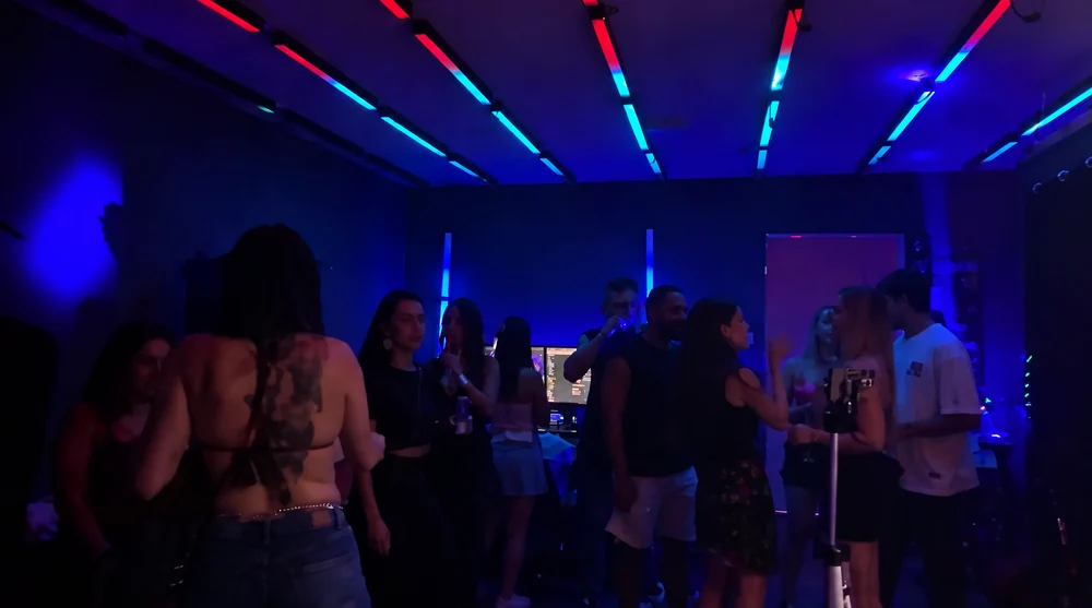 Convidados dançando sob iluminação azul e ciano